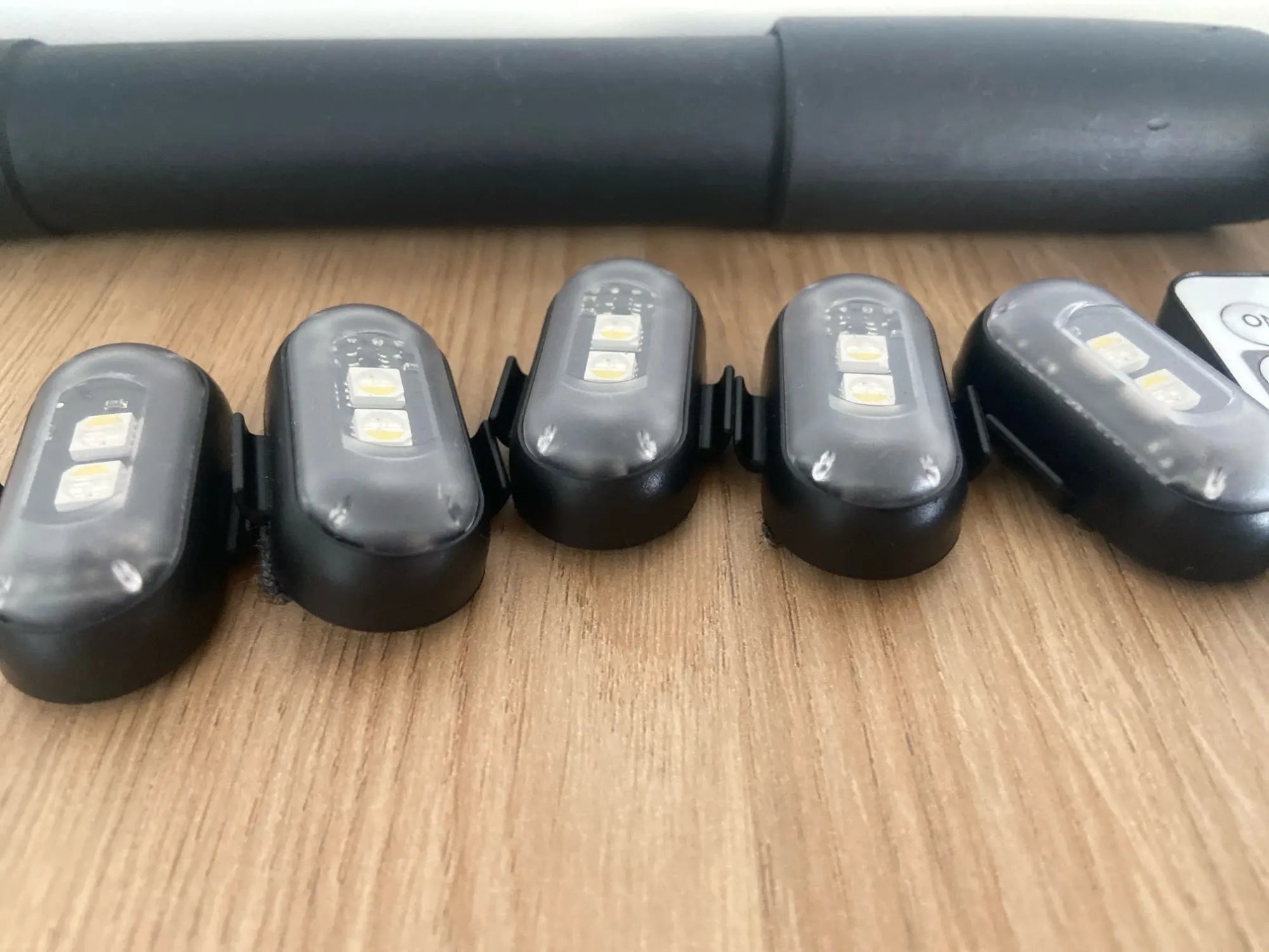 RGB LED light pucks lined up on a table showing size and clip mounting